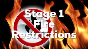 Stage 1 Fire Restrictions on black background with fire